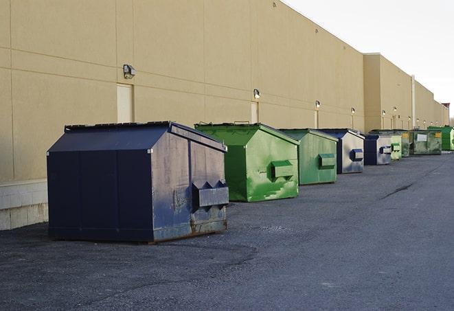 a row of blue construction dumpsters on a job site in Farmington